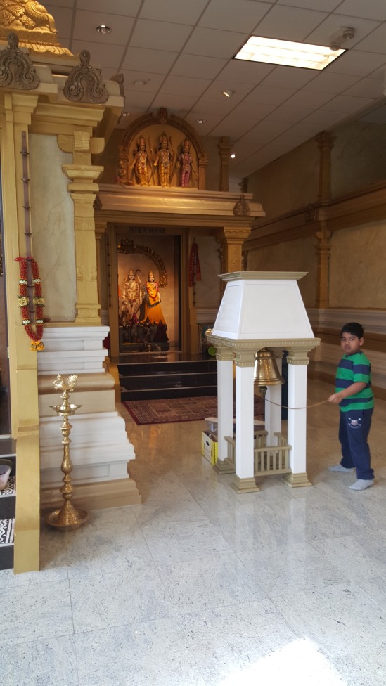 View of temple interior to the right of Shri Venkateshwar - Ram Parivar, and some kid ringin' a bell